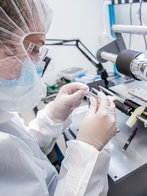 Cleanroom Woman wearing clean room gear while working and inspecting a medical object